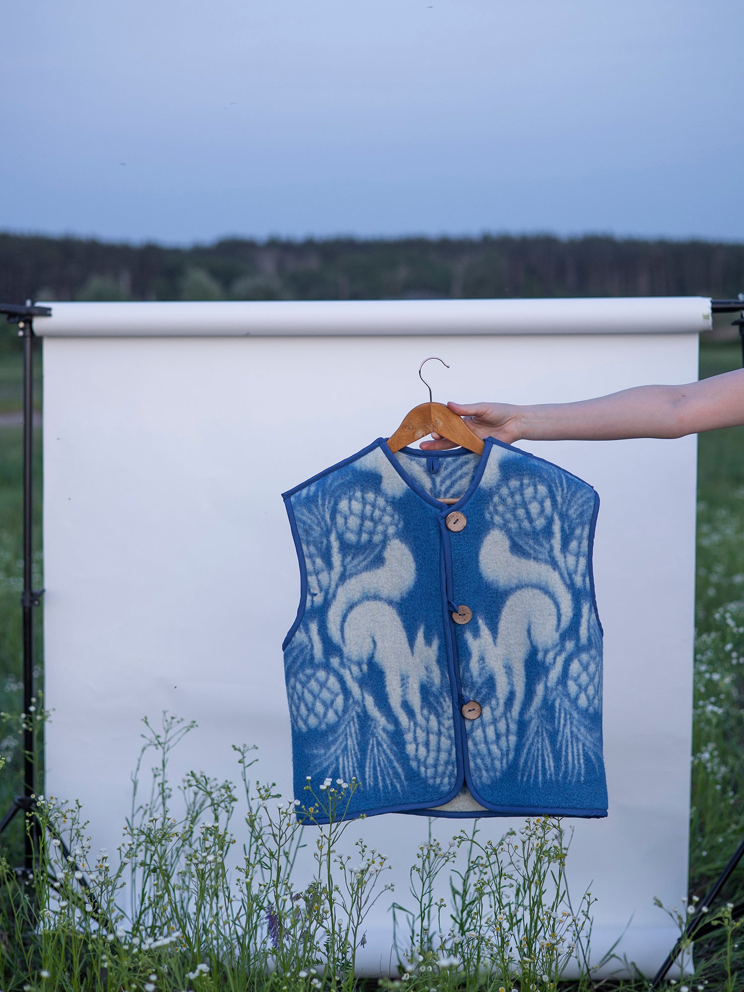 vest hanging on wooden hanger upcycled wool blanket vest ‘squirrels & pine’ print